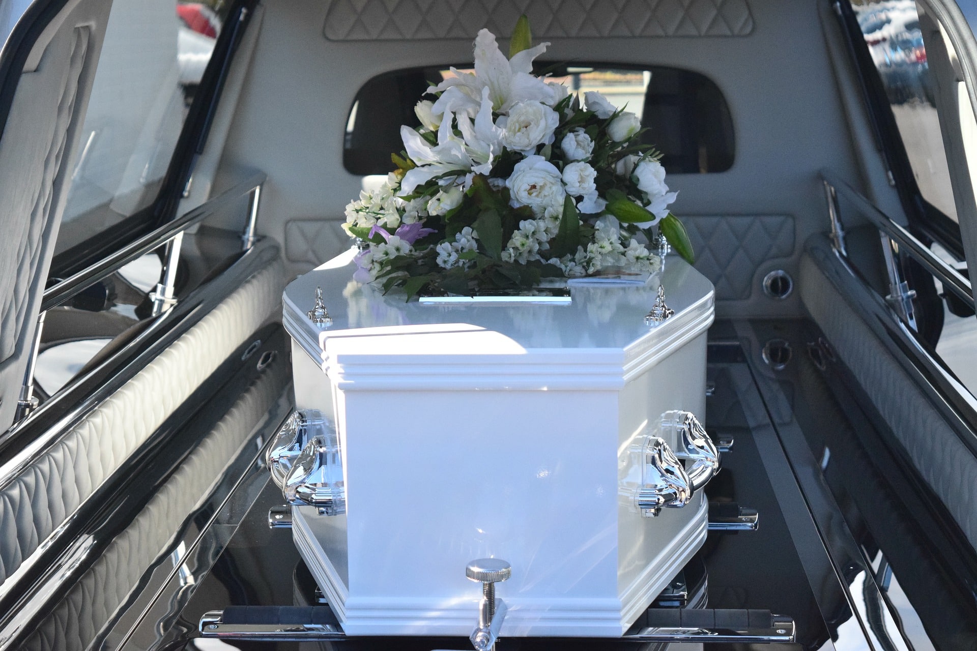white coffin with funeral flowers
